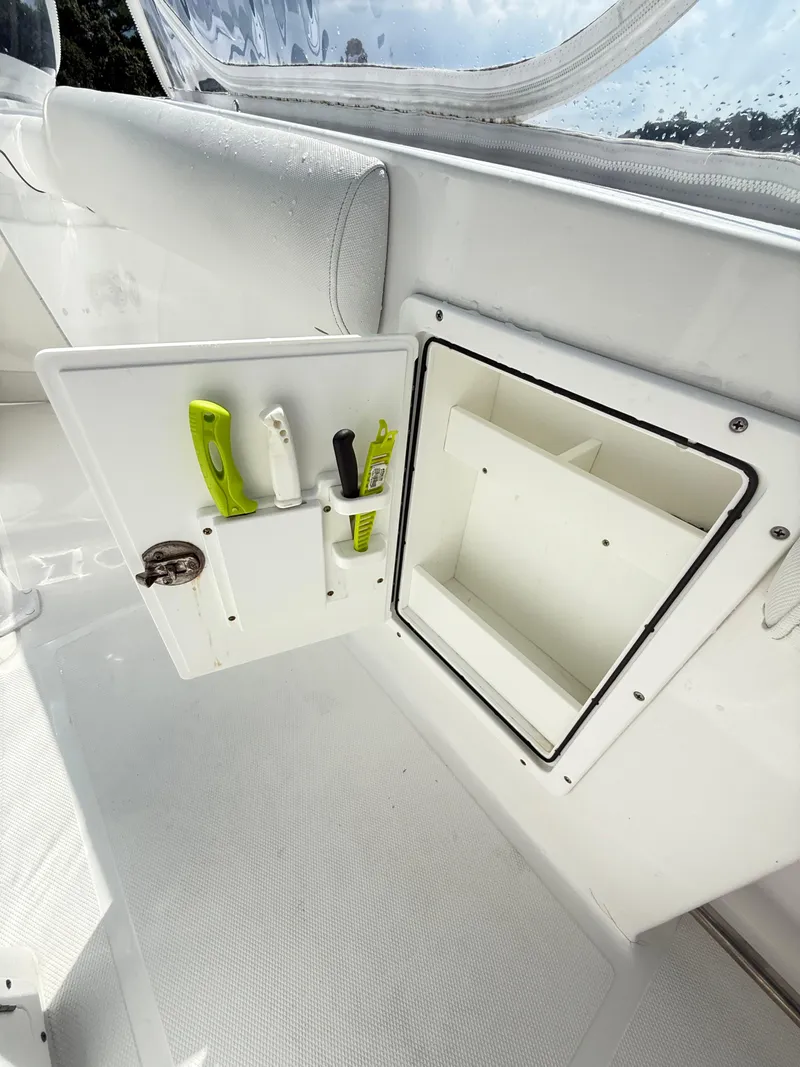 Slide: The Image of 2018 Sea Hunt Gamefish 30 storage compartment with tools and open hatch. - 34