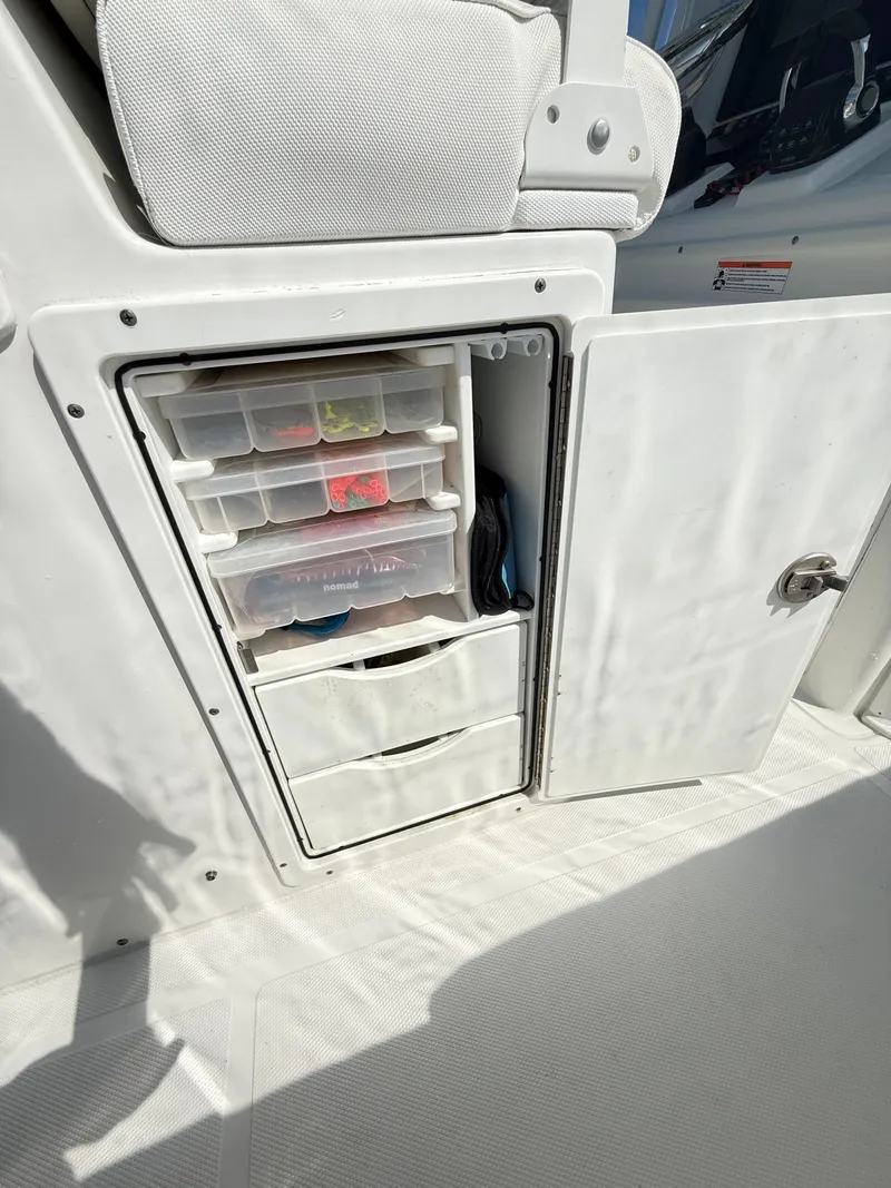 Slide: The Image of Storage compartment on 2018 Sea Hunt Gamefish 30, featuring organized tackle boxes and drawers. - 36