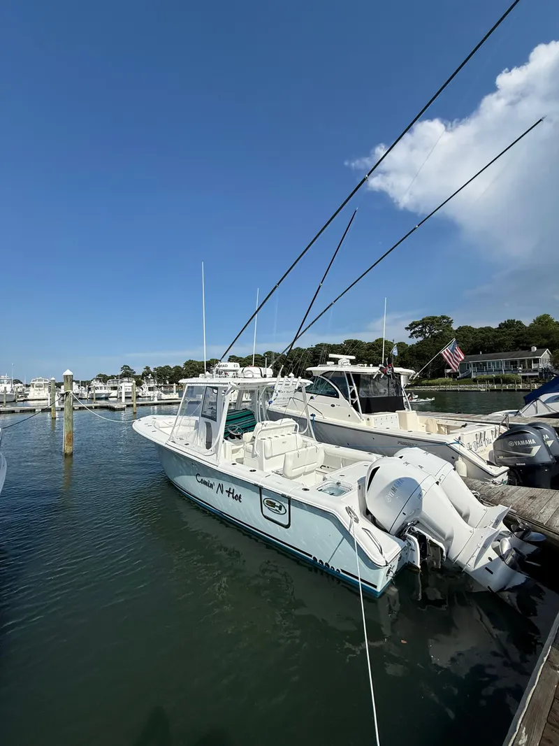 Slide: The Image of 2018 Sea Hunt Gamefish 30 boat docked, featuring forward seating and fishing rods. - 4