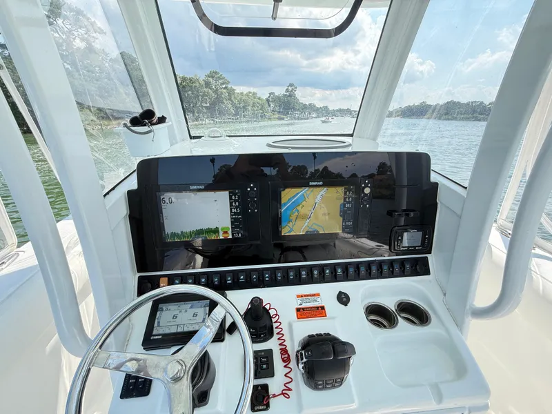 Slide: The Image of 2018 Sea Hunt Gamefish 30 dashboard with navigation screens and steering wheel on a sunny day. - 5