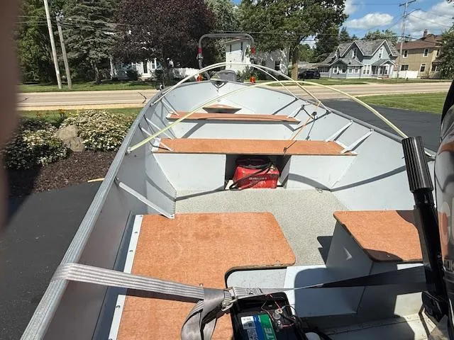 Slide: The Image of 1999 Lund SSV-16 Tiller boat with wooden seats, parked on a driveway. - 4