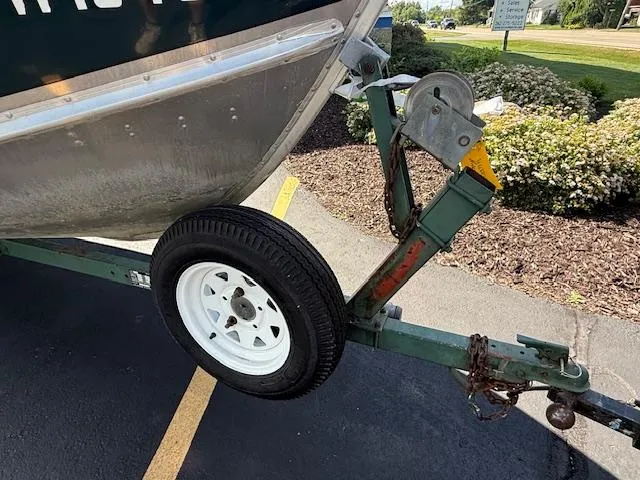 Slide: The Image of 1999 Lund SSV-16 Tiller boat on trailer with spare tire, parked on asphalt. - 6