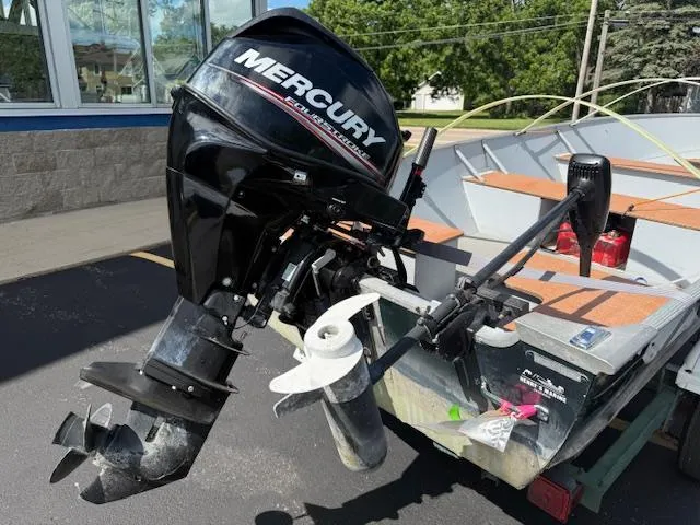 Slide: The Image of 1999 Lund SSV-16 Tiller boat with Mercury outboard motor, parked outdoors. - 8