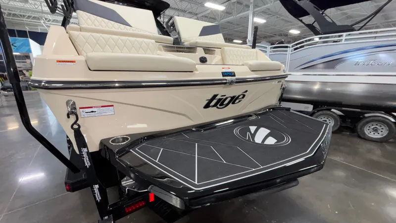 Slide: The Image of 2025 Tigé Z5 boat rear view in showroom, featuring sleek design and swim platform. - 4