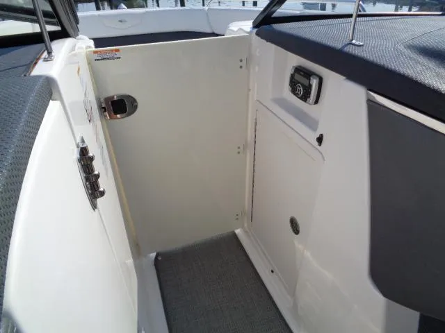 Slide: The Image of 2015 Chaparral 307 SSX boat interior with storage compartment and control panel. - 11
