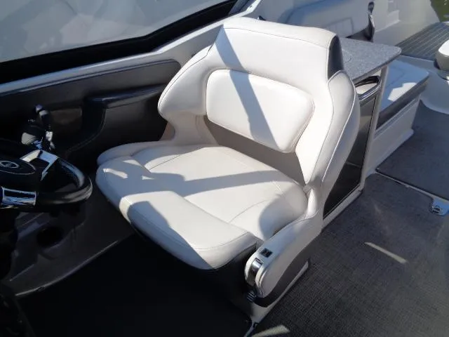 Slide: The Image of 2015 Chaparral 307 SSX boat interior with white captain's seat and steering wheel. - 15