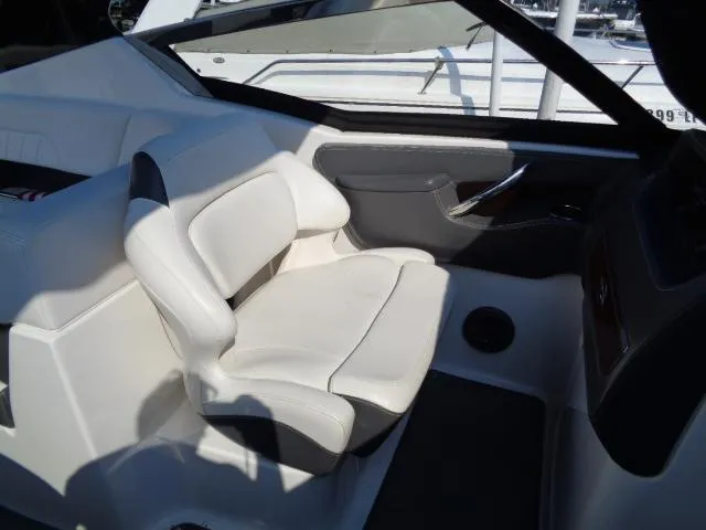Slide: The Image of 2015 Chaparral 307 SSX boat interior with white seating and sleek design. - 18