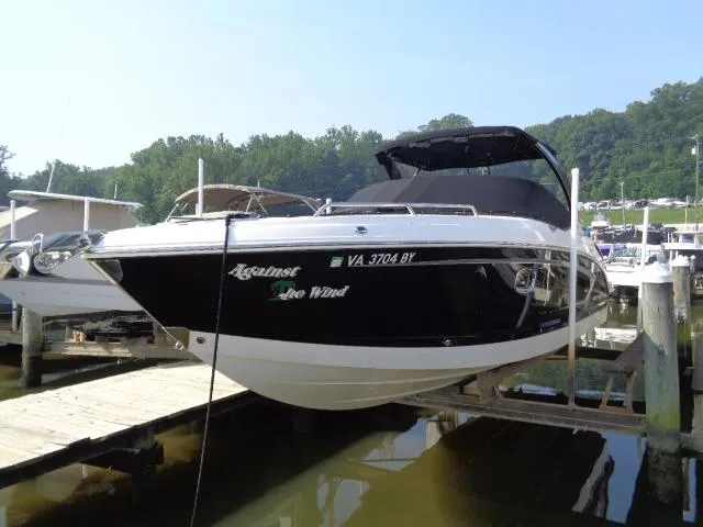 Slide: The Image of 2015 Chaparral 307 SSX boat docked at a marina, featuring sleek black and white design. - 2