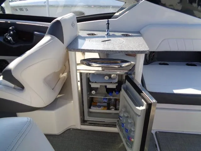Slide: The Image of 2015 Chaparral 307 SSX boat interior with open mini fridge and sink. - 22