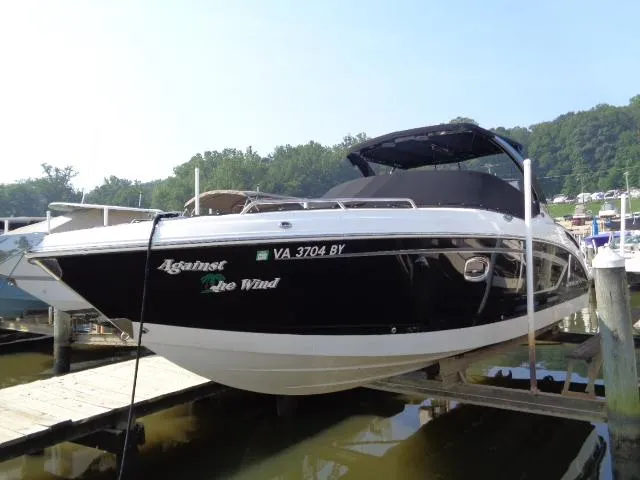 Slide: The Image of 2015 Chaparral 307 SSX boat docked, black and white exterior, named "Against the Wind." - 3