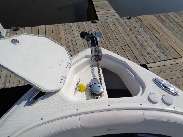 Slide: The Image of 2015 Chaparral 307 SSX boat anchor compartment with open hatch near wooden dock. - 5
