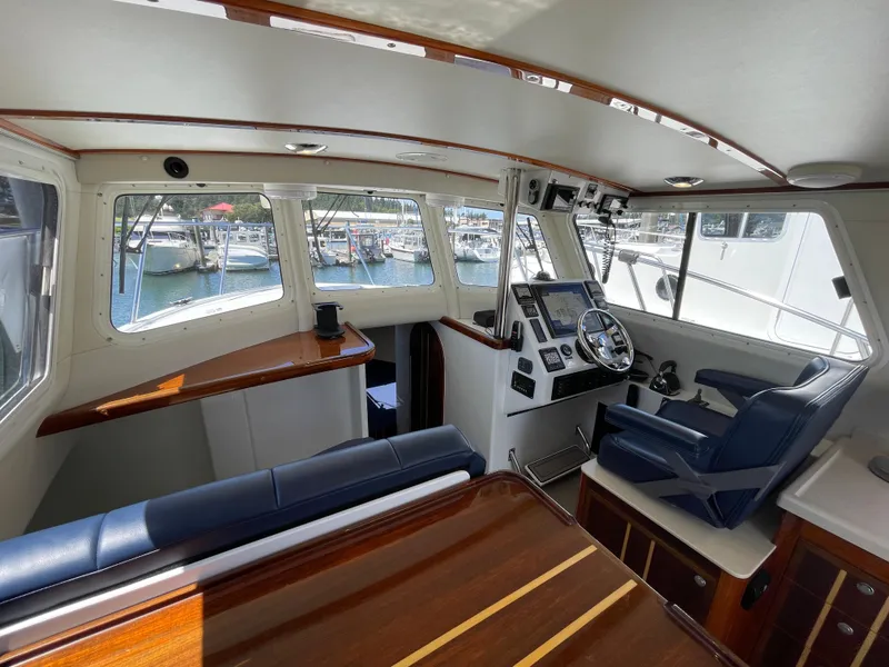 Slide: The Image of Interior of 2016 Lindell Ocean Roamer boat with helm, seating, and marina view. - 11