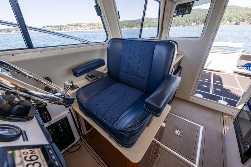 Slide: The Image of Captain's chair in 2016 Lindell Ocean Roamer boat cockpit, overlooking scenic waters. - 13