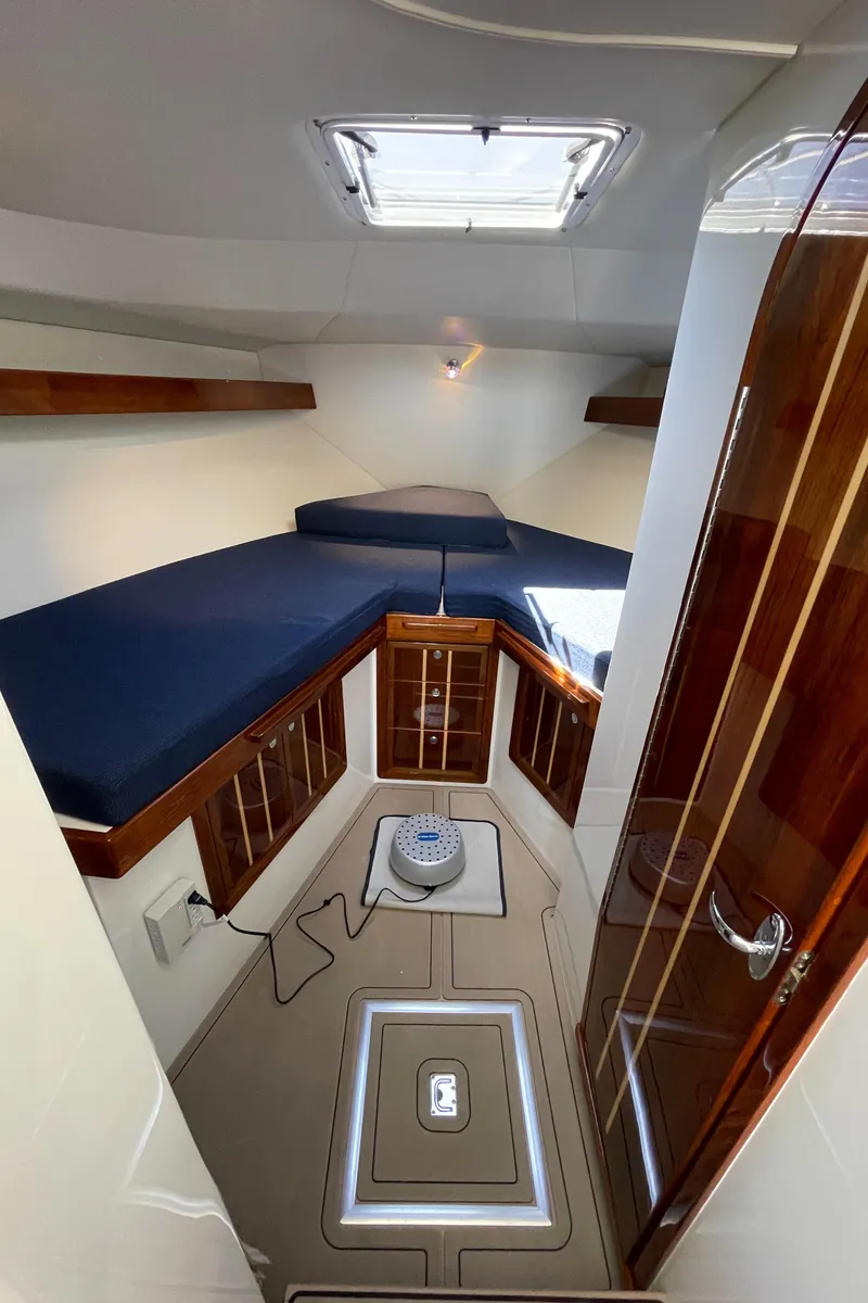 Slide: The Image of Interior of 2016 Lindell Ocean Roamer boat with wooden cabinets and blue cushions. - 19