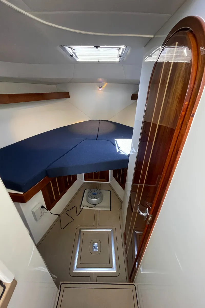 Slide: The Image of 2016 Lindell Ocean Roamer cabin interior with blue cushions and wooden accents. - 20