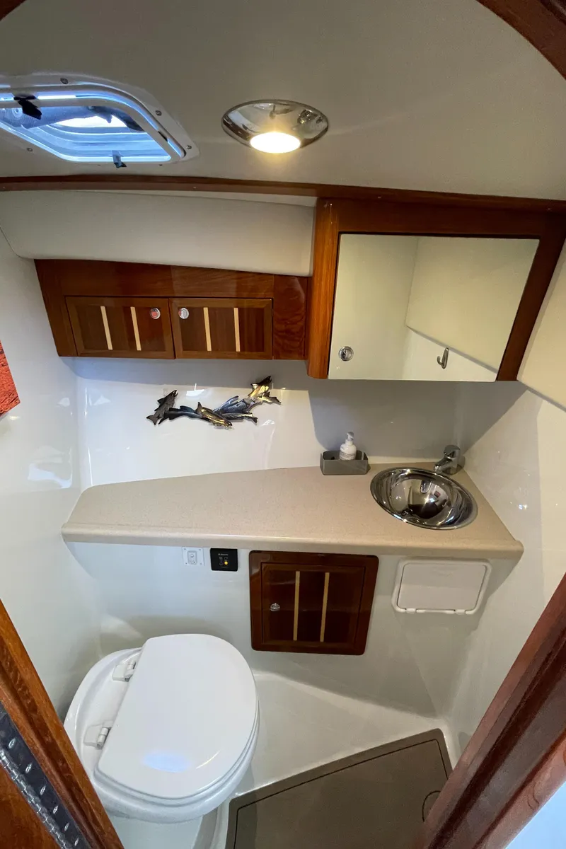 Slide: The Image of 2016 Lindell Ocean Roamer bathroom with sink, toilet, and wooden cabinetry. - 21
