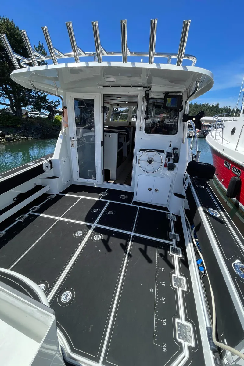 Slide: The Image of 2016 Lindell Ocean Roamer boat deck with fishing rod holders and spacious seating area. - 23