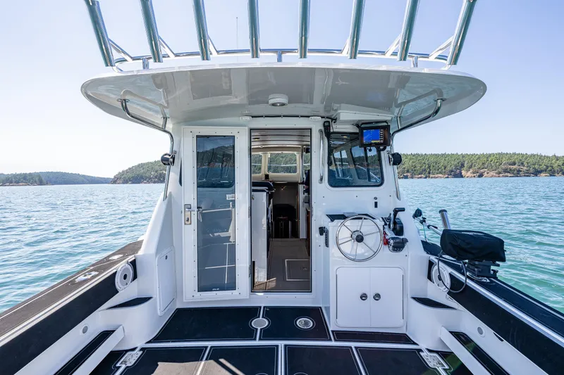 Slide: The Image of 2016 Lindell Ocean Roamer boat interior with steering wheel, open sea view, and clear skies. - 26