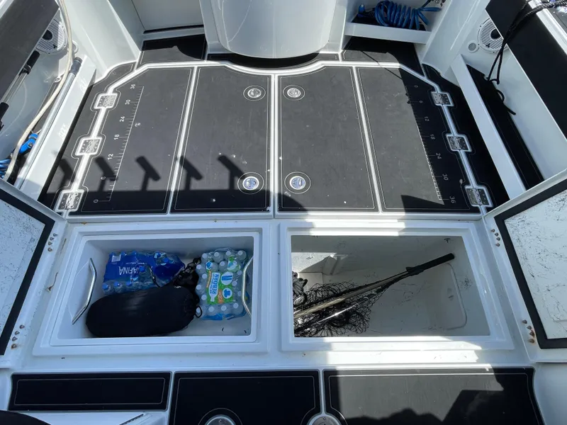 Slide: The Image of 2016 Lindell Ocean Roamer deck with storage compartments, fishing gear, and bottled water. - 30