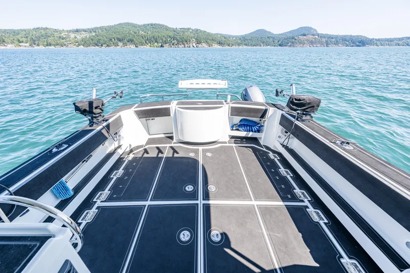 Slide: The Image of 2016 Lindell Ocean Roamer boat deck with fishing gear on a serene lake. - 32