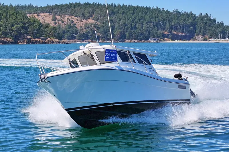 Slide: The Image of 2016 Lindell Ocean Roamer boat cruising on blue water, forested shoreline in background. - 4