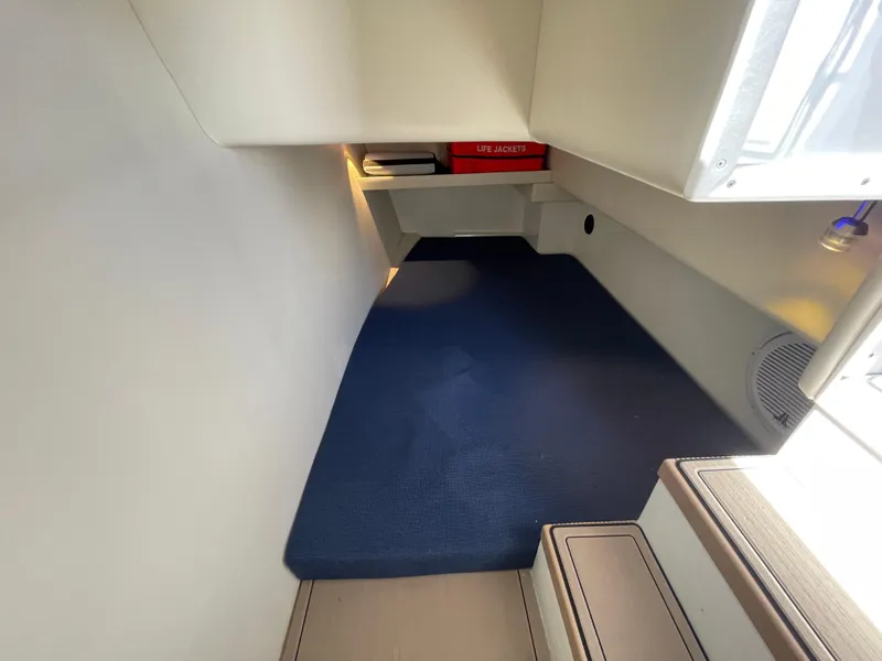 Slide: The Image of 2016 Lindell Ocean Roamer interior cabin with blue carpet and life jackets storage. - 6