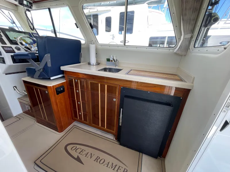 Slide: The Image of Interior of 2016 Lindell Ocean Roamer boat with helm and kitchenette area. - 7