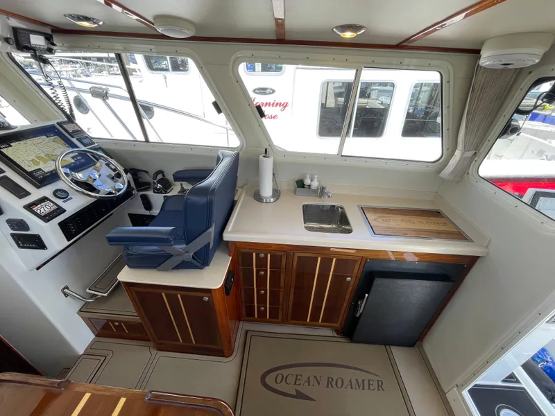 Slide: The Image of Interior of 2016 Lindell Ocean Roamer boat with helm, sink, and wooden cabinetry. - 8