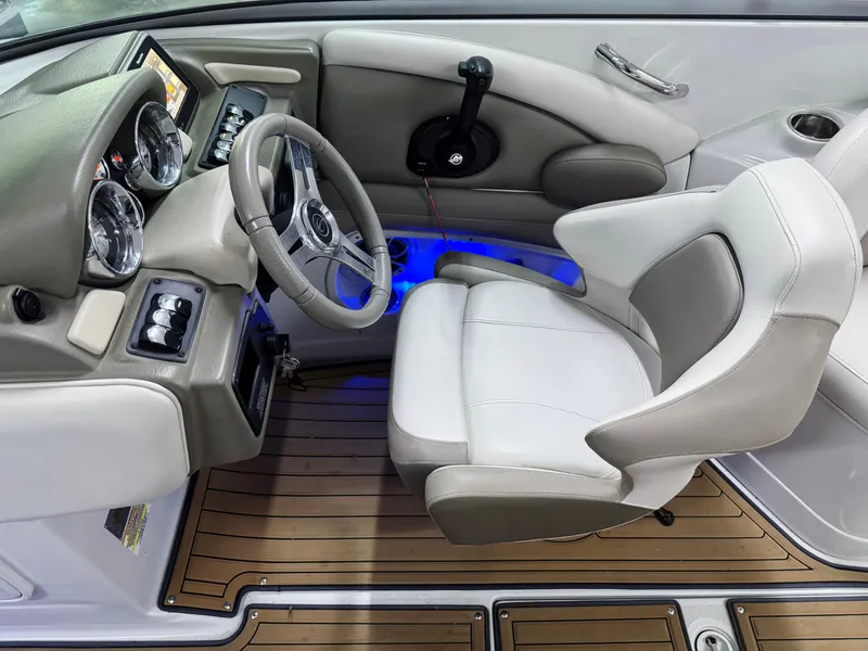 Slide: The Image of 2016 Crownline 270 SS boat cockpit with steering wheel, gauges, and white captain's chair. - 11