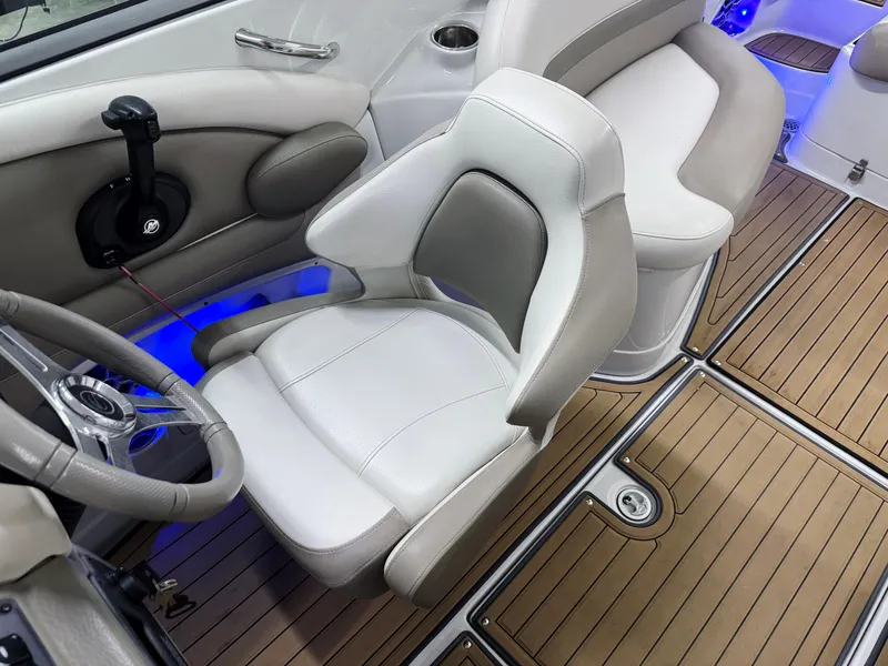 Slide: The Image of 2016 Crownline 270 SS boat interior with white seating and wood-style flooring. - 12