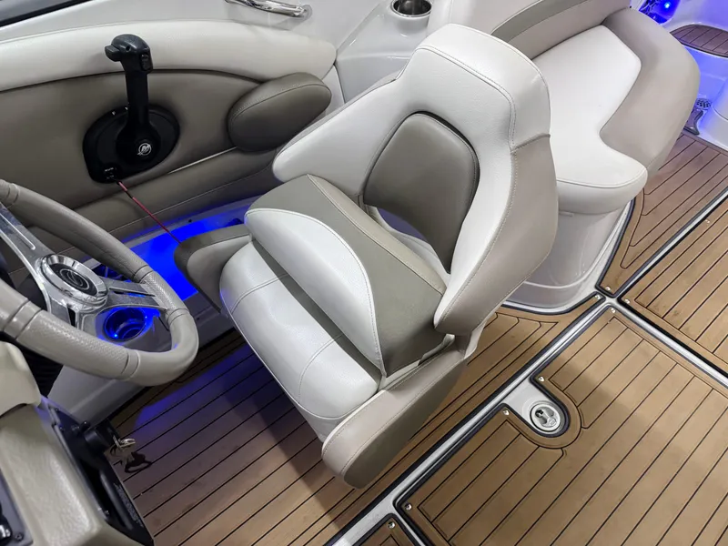 Slide: The Image of Captain's seat and steering wheel of 2016 Crownline 270 SS boat, featuring elegant wood flooring. - 13
