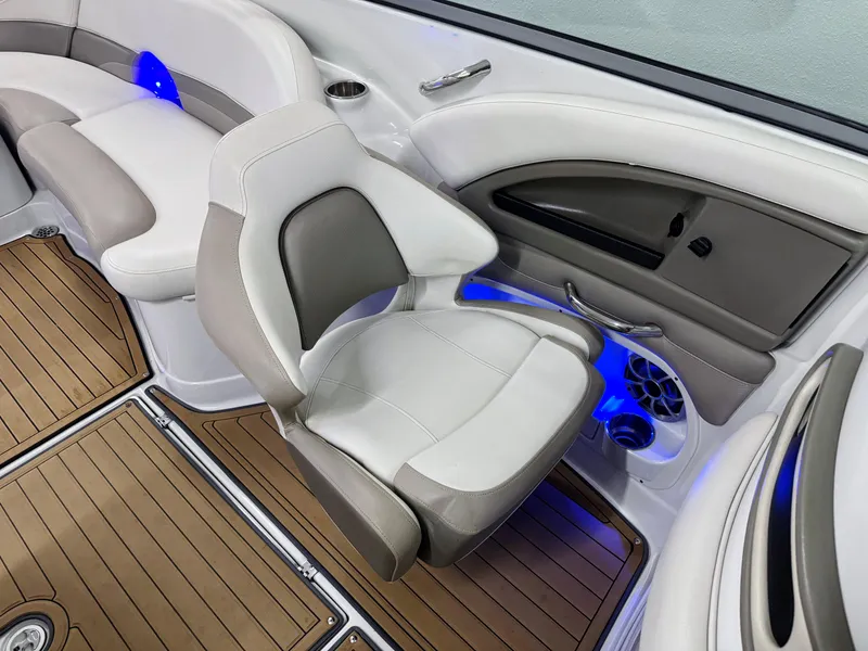 Slide: The Image of 2016 Crownline 270 SS boat interior with white seating, wood flooring, and blue LED lighting. - 15