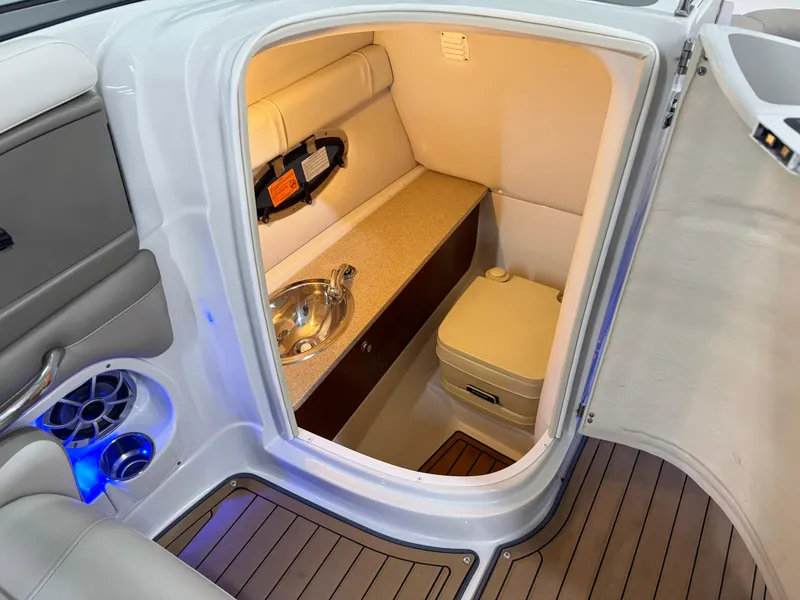 Slide: The Image of 2016 Crownline 270 SS boat interior with compact bathroom and sink. - 18