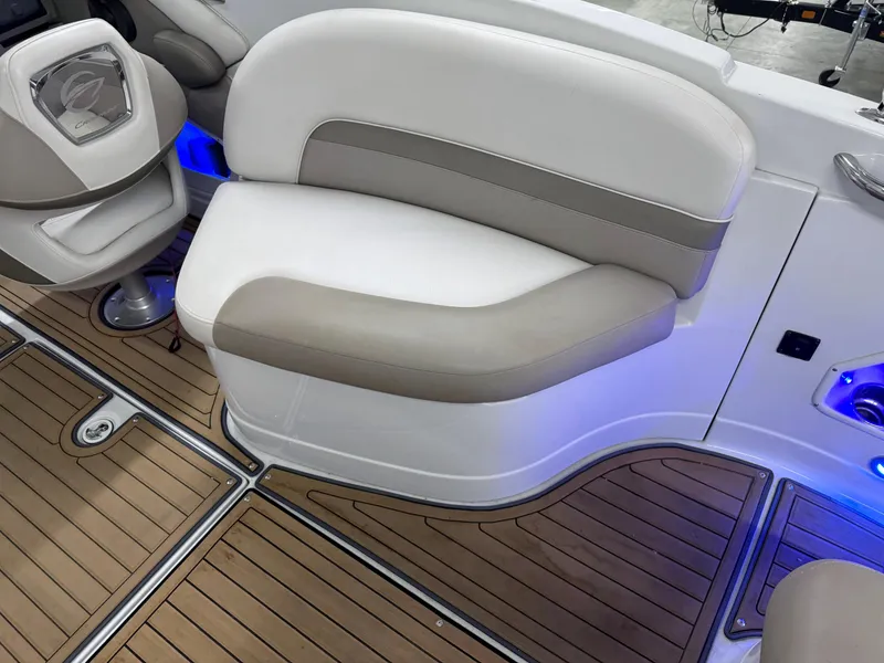 Slide: The Image of 2016 Crownline 270 SS boat interior with beige seating and wood-patterned flooring. - 27