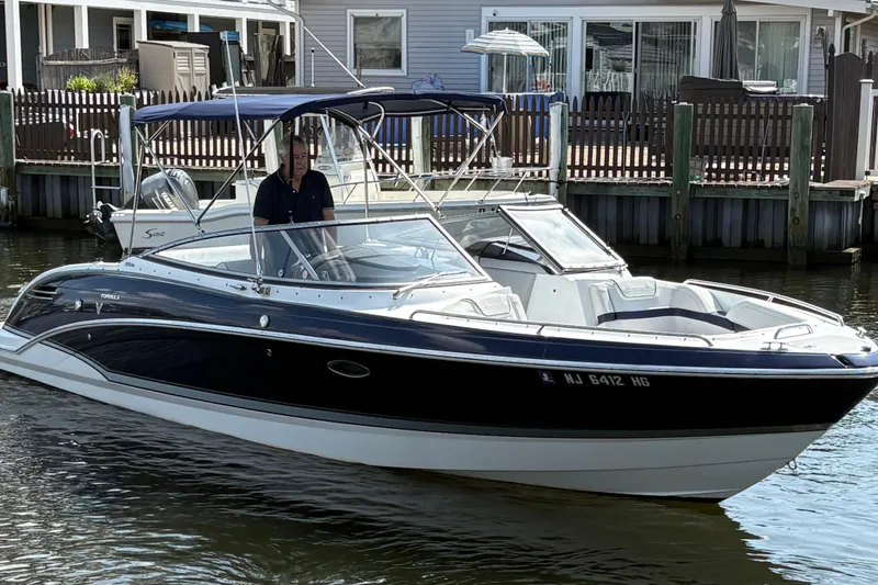 Slide: The Image of 2014 Formula 270 Bowrider boat docked near waterfront homes. - 0