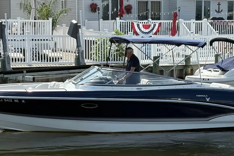 Slide: The Image of 2014 Formula 270 Bowrider boat docked near waterfront homes. - 1