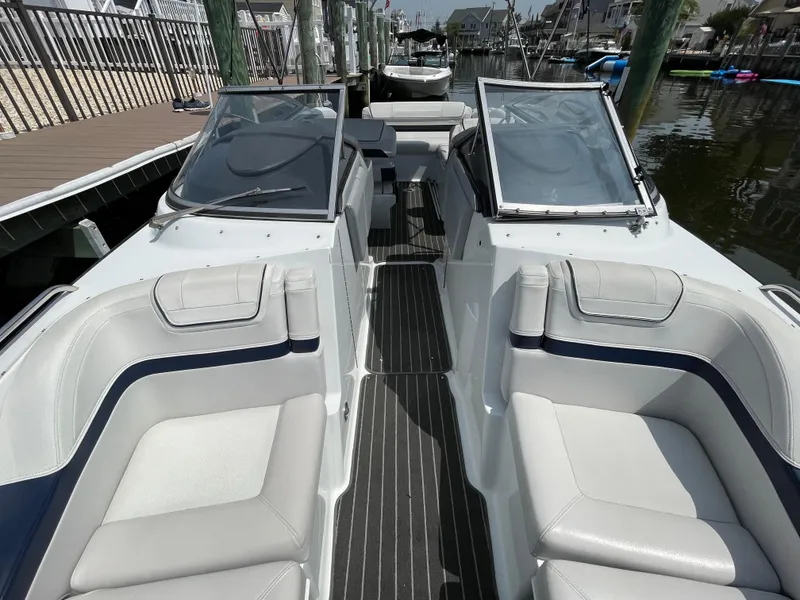 Slide: The Image of 2014 Formula 270 Bowrider interior with sleek seating and dual windshields, docked at marina. - 18