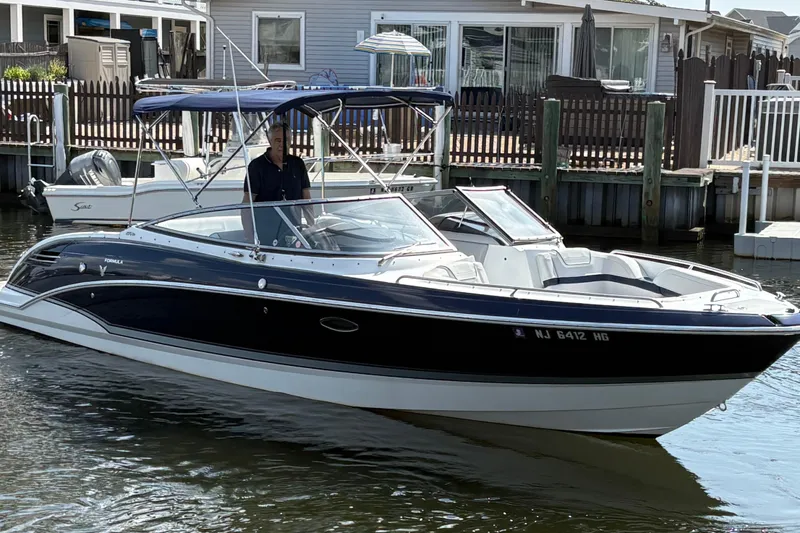 Slide: The Image of 2014 Formula 270 Bowrider boat docked in a residential marina setting. - 2