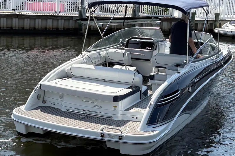 Slide: The Image of 2014 Formula 270 Bowrider boat with canopy, docked on calm water. - 4
