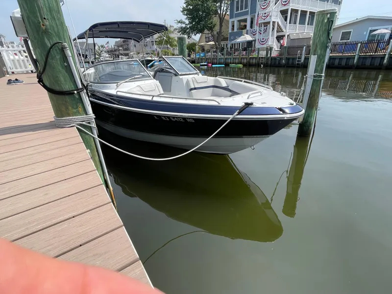 Slide: The Image of 2014 Formula 270 Bowrider boat docked at a marina, calm water, sunny day. - 5