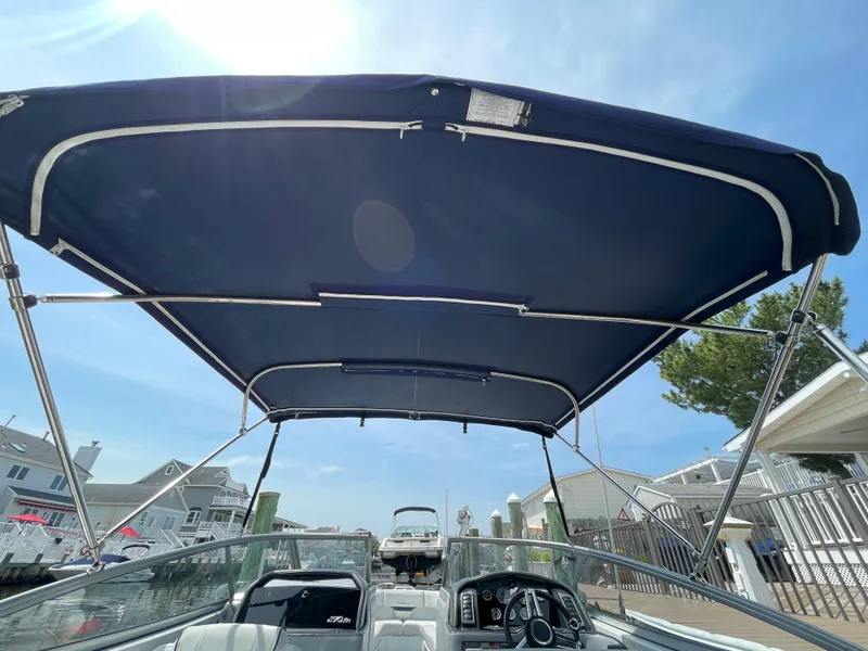 Slide: The Image of 2014 Formula 270 Bowrider with blue canopy, docked under clear sky. - 60