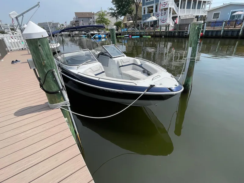Slide: The Image of 2014 Formula 270 Bowrider docked at a marina, calm water, residential backdrop. - 7