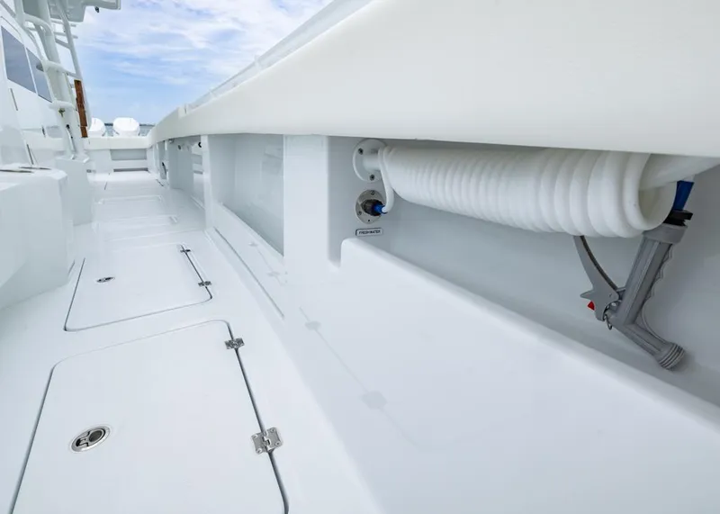 Slide: The Image of 2026 Invincible 40 Catamaran deck with storage compartments and coiled hose. - 10