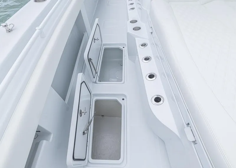 Slide: The Image of 2026 Invincible 40 Catamaran deck with open storage compartments and rod holders. - 12