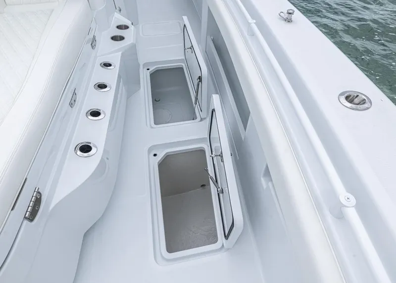 Slide: The Image of 2026 Invincible 40 Catamaran deck with open storage compartments and rod holders. - 13