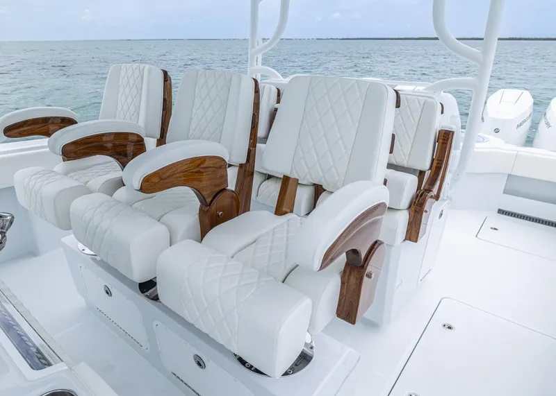 Slide: The Image of Luxurious seating on 2026 Invincible 40 Catamaran, featuring white quilted upholstery and wooden accents. - 18