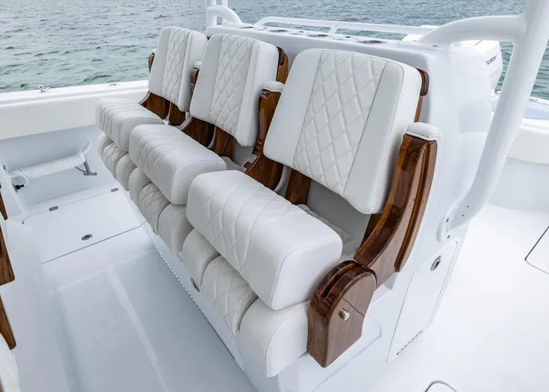Slide: The Image of Luxurious seating on 2026 Invincible 40 Catamaran, featuring white quilted upholstery and wooden accents. - 19