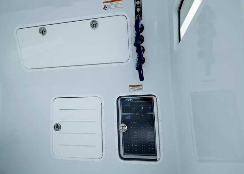 Slide: The Image of Interior control panel of 2026 Invincible 40 Catamaran, featuring storage compartments and switches. - 31