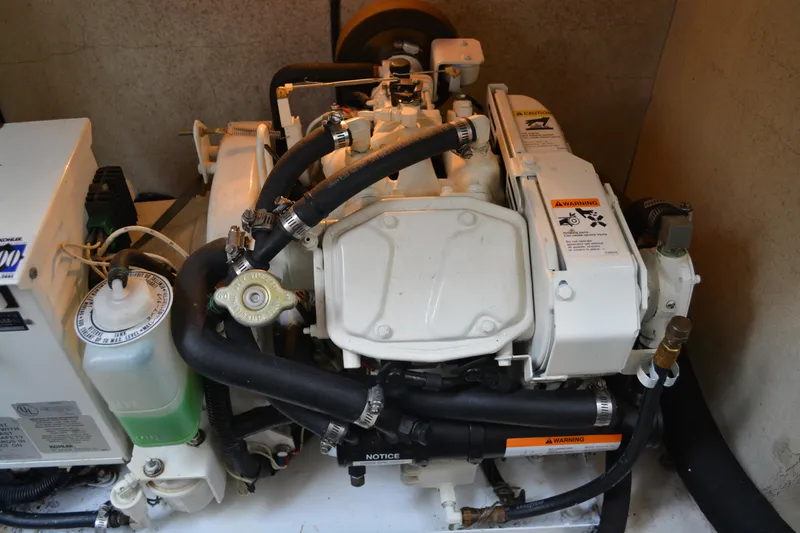 Slide: The Image of Engine compartment of a 1998 Formula 31 PC boat, featuring hoses and warning labels. - 39