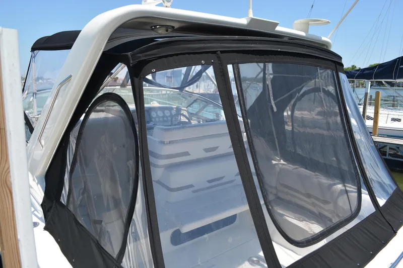 Slide: The Image of 1998 Formula 31 PC boat with enclosed cockpit and clear panels at a marina. - 9